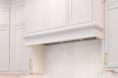Two-tone white kitchen with walnut Buckskin-stained island and marble counters in Raleigh, NC