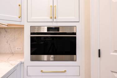 Two-tone white kitchen with walnut Buckskin-stained island and marble counters in Raleigh, NC