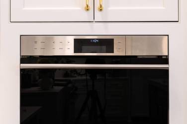 Two-tone white kitchen with walnut Buckskin-stained island and marble counters in Raleigh, NC