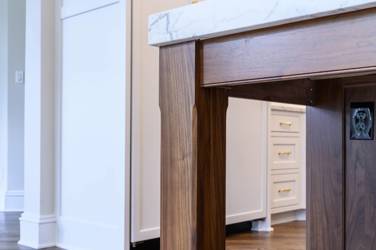 Two-tone white kitchen with walnut Buckskin-stained island and marble counters in Raleigh, NC