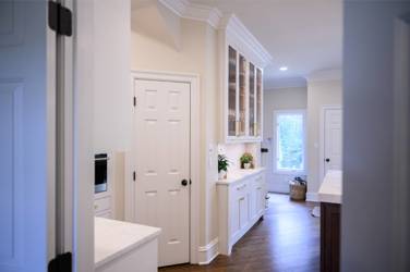 Two-tone white kitchen with walnut Buckskin-stained island and marble counters in Raleigh, NC