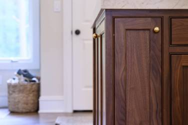 Two-tone white kitchen with walnut Buckskin-stained island and marble counters in Raleigh, NC