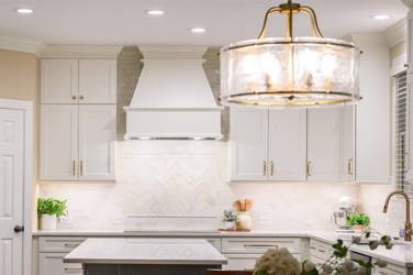 White kitchen with gray island and herringbone tile backsplash in Cary, NC