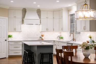 White kitchen with gray island and herringbone tile backsplash in Cary, NC