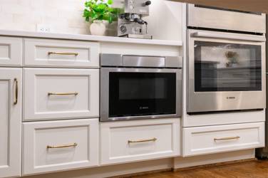 White kitchen with gray island and herringbone tile backsplash in Cary, NC