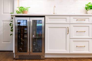 White kitchen with gray island and herringbone tile backsplash in Cary, NC