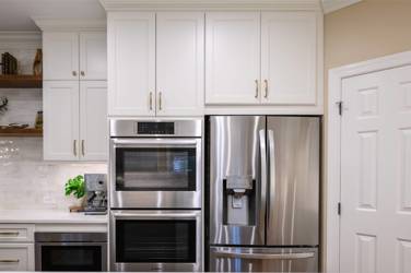 White kitchen with gray island and herringbone tile backsplash in Cary, NC