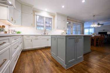 White kitchen with gray island and herringbone tile backsplash in Cary, NC