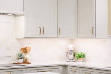 White kitchen with gray island and herringbone tile backsplash in Cary, NC