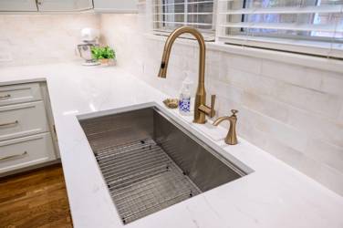 White kitchen with gray island and herringbone tile backsplash in Cary, NC