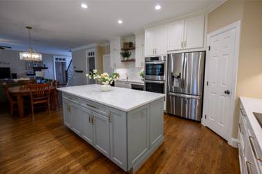 White kitchen with gray island and herringbone tile backsplash in Cary, NC
