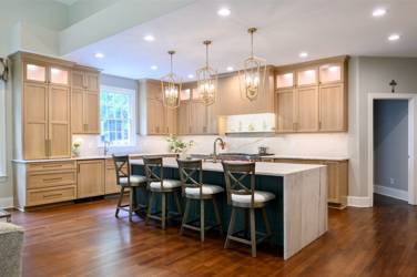 White oak kitchen with sage green island and white quartzite waterfall counters in Raleigh, NC