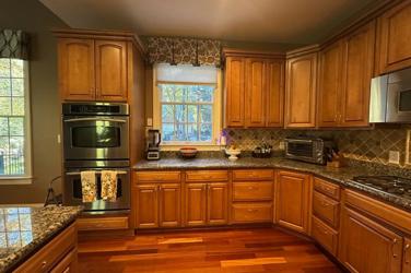 White oak kitchen with sage green island and white quartzite waterfall counters in Raleigh, NC