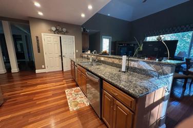 White oak kitchen with sage green island and white quartzite waterfall counters in Raleigh, NC