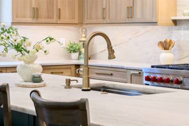 White oak kitchen with sage green island and white quartzite waterfall counters in Raleigh, NC