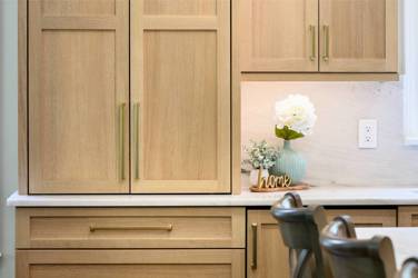 White oak kitchen with sage green island and white quartzite waterfall counters in Raleigh, NC