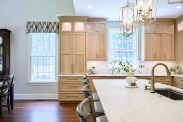 White oak kitchen with sage green island and white quartzite waterfall counters in Raleigh, NC