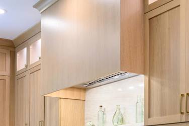 White oak kitchen with sage green island and white quartzite waterfall counters in Raleigh, NC