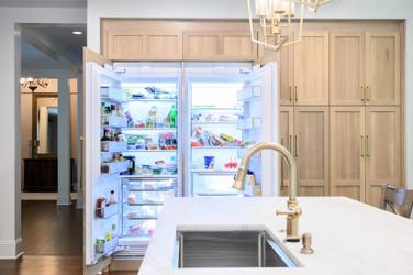 White oak kitchen with sage green island and white quartzite waterfall counters in Raleigh, NC