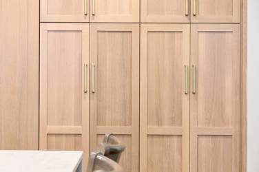 White oak kitchen with sage green island and white quartzite waterfall counters in Raleigh, NC