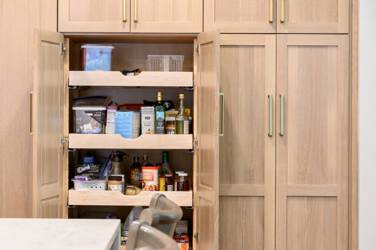 White oak kitchen with sage green island and white quartzite waterfall counters in Raleigh, NC